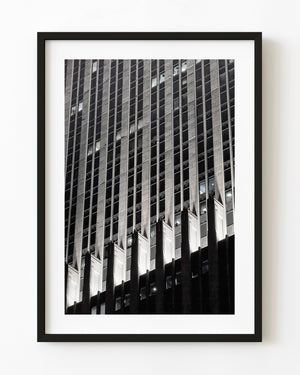 Black and white night photograph of a Chicago office facade with bright stone details beneath dark windows.