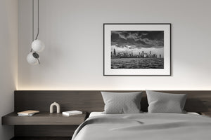 Monochrome Chicago lakefront cityscape with textured water and heavy clouds above the skyline.