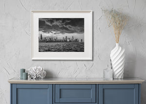 A broad view across Lake Michigan shows Chicago’s skyline beneath a turbulent sky.