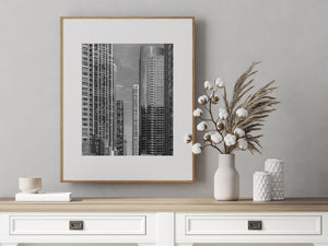 Monochrome Chicago architecture with closely spaced skyscrapers and a small tower beyond.
