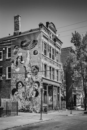 Painted faces and large hands cover the facade of a Chicago building in monochrome.