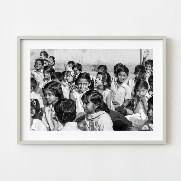 Black and white image of children sitting together and smiling