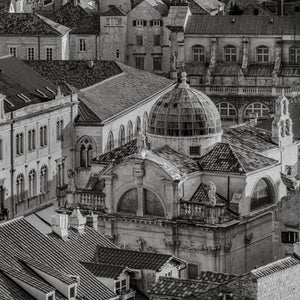 Historyczne kamienne budynki Dubrownika i monochromatyczny pejzaż miejski z kopułą kościoła