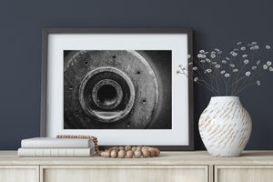 Monochrome mechanical detail with layered rings, bolts and weathered metal surfaces.