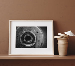An aged metal component creates a geometric abstract of rings and repeated small openings.