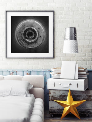 Aged machinery creates a geometric black and white pattern of circles, shadows and small holes.