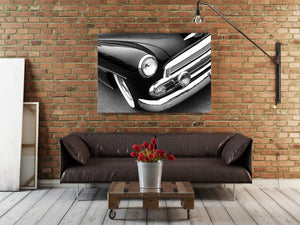 Horizontal black and white photograph of a Chevrolet front corner with circular light and polished chrome.