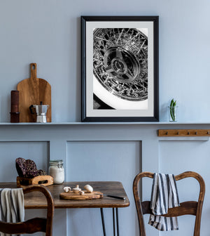 A pale whitewall curves around a dense pattern of chrome spokes on a classic Ford wheel.