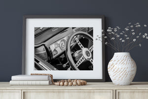 Classic car steering wheel and dashboard photographed in black and white