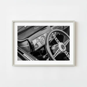 Black and white photograph of classic Ford convertible steering wheel and dashboard
