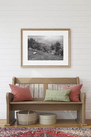 Monochrome farm setting with scattered laundry and distant hills
