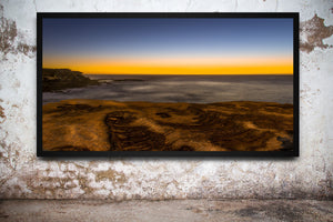 Panoramic Clovelly Beach landscape showing rock pools, open sea and a bright strip of golden dawn.