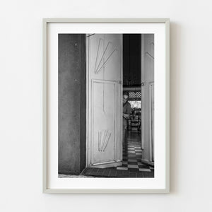 Woman peeking through colonial doorway in Cartagena black and white photograph