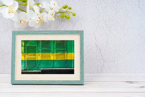 Yellow paint runs across green carriage panels with rows of dark louvres.