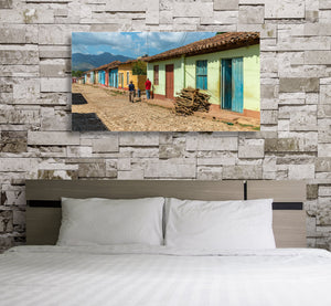 Wide travel photograph of Trinidad’s colourful architecture under a cloudy blue sky.