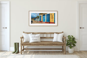 A panoramic Trinidad street photograph shows colonial facades, overhead wires and cobblestones.