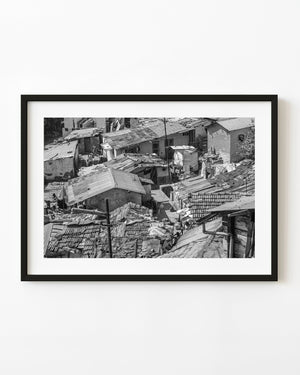 Black and white photograph of closely packed houses and layered rooftops in Coonoor, India.