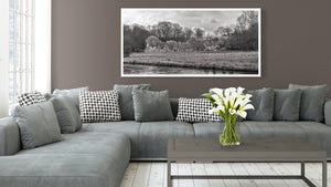 Panoramic black and white photograph of Cotswolds cottages and a peaceful river foreground.