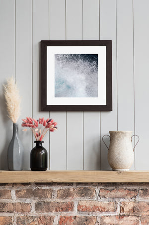 Pale turquoise water and bright foam create an abstract coastal pattern.