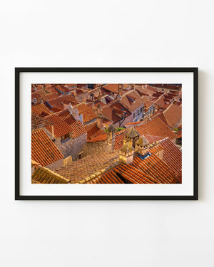 Red tile rooftops and weathered stone chimneys form a dense architectural pattern in Croatia.