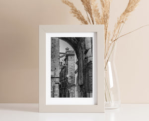 Worn blocks and curved brickwork surround a view into a narrow Croatian street.