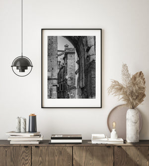 Black and white Croatian street photograph highlighting an old archway and tightly spaced buildings.