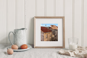 Sunlit roof tiles and weathered building walls create a layered Croatian town scene.