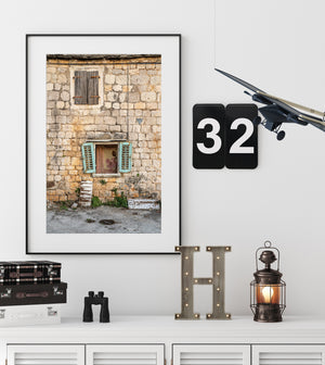 Croatian house photograph highlighting turquoise shutters, aged stonework and worn window details.