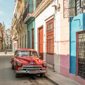 Classic Cuban car beside colorful colonial buildings