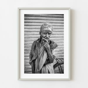 Black and white portrait of elderly woman with walking stick in India