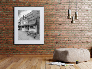 The angled facade of Curley’s Tap combines brick walls, a sloping awning and a sidewalk bench.