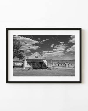 An old general store with a Pepsi sign stands beneath scattered clouds in Currie Nevada, photographed in black and white.
