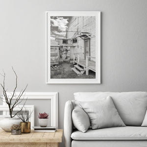 Narrow wooden steps and a landing contrast with rough ground and worn Nevada building walls.