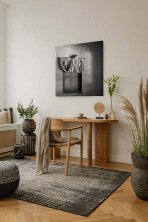 A quiet abandoned home interior reveals draped fabric and narrow traces of window light.