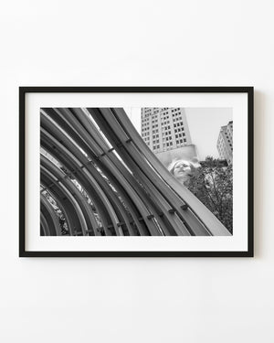 Curved metal ribs fill an upward view of Dallas’s Discovery District in black and white.