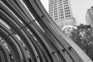 Sweeping metal arcs contrast with a tower and screen portrait at the Discovery District.