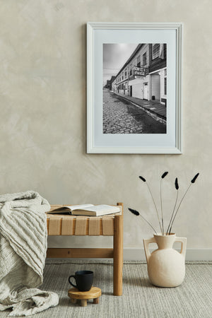 Stone paving leads past aged architecture beneath overhead wires at Custom House Wharf.