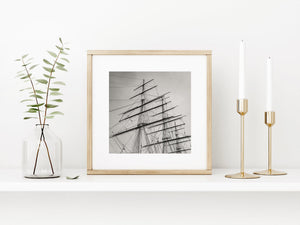 Horizontal yards cross upright masts amid delicate diagonal lines of rigging.