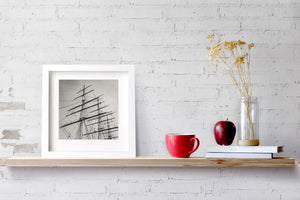 The Cutty Sark’s upper rigging forms repeated shapes against a softly toned sky.