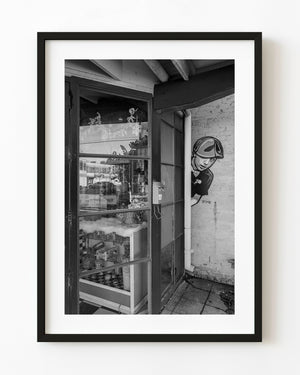 A candy-shop doorway and painted wall figure in Dallas Deep Ellum, photographed in black and white.