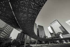 An upward view contrasts the perforated pavilion canopy with angular Dallas skyscrapers.