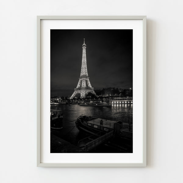 Moody Eiffel Tower at night with boats