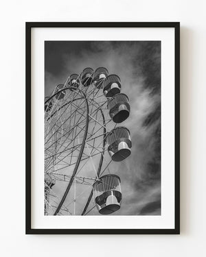 Darling Harbour Ferris wheel cars curve across a cloudy sky in a black and white Sydney photograph.