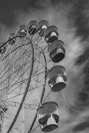 A close upward view follows suspended gondolas along the rim of a Sydney Ferris wheel.