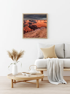 A rough foreground ledge overlooks sunlit sandstone formations and distant Utah canyon walls.