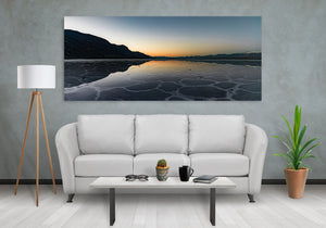 Cool blue reflections spread toward the foreground across Death Valley’s patterned salt surface.