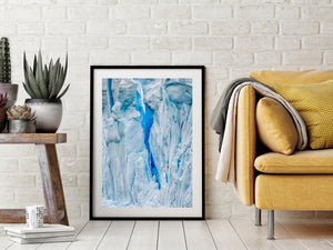 Sculpted Antarctic ice forms tall pale shapes beside a vivid blue crevasse.