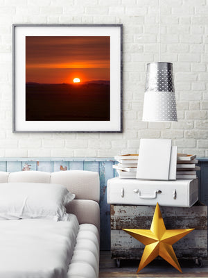 A bright sunrise contrasts with subdued fields and distant hills in Quebec.