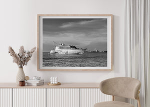 Abandoned-looking yacht with a small boat alongside, black and white coastal photograph.