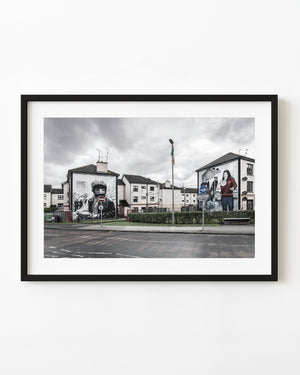 Large Bogside murals facing across a quiet Derry street in Northern Ireland.